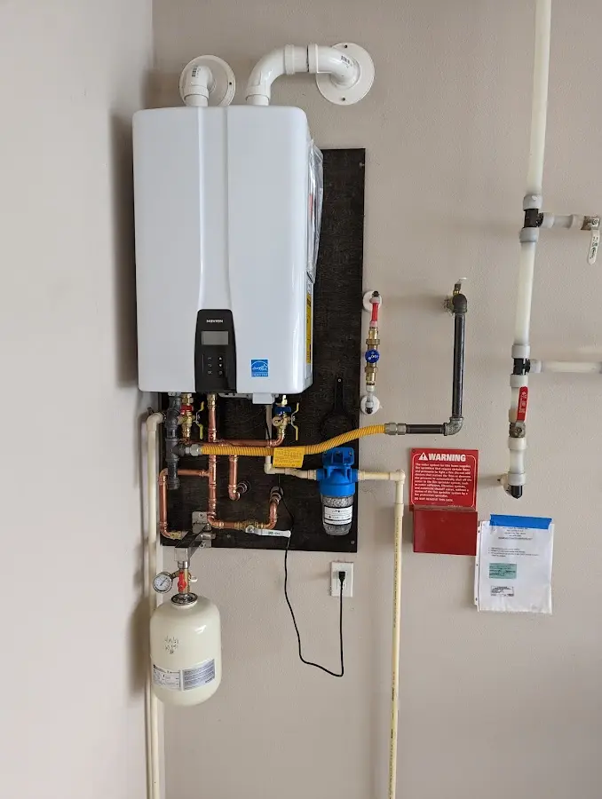 Professional plumber installing copper piping in a UtqiagÃÂvik home